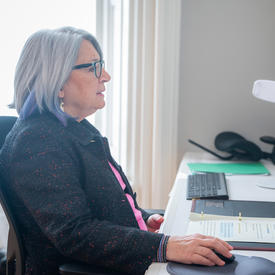 La gouverneure générale est assise devant un ordinateur. Elle participe à un événement virtuel.