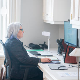 La gouverneure générale est assise devant un ordinateur. Elle participe à un événement virtuel.