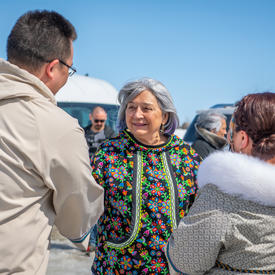 La gouverneure générale parle avec deux résidents.