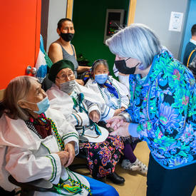 La gouverneure générale s'entretient avec des personnes de la communauté.