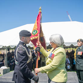 La gouverneure générale remet un drapeau.