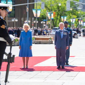 Leurs Altesses Royales sont debout sur un tapis rouge à l'extérieur.