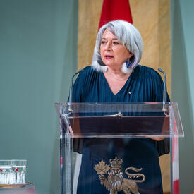The Governor General standing at a podium.