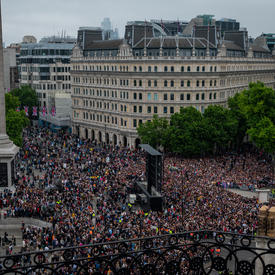 London, United Kingdom. There is a large crowd between the buildings and monuments.