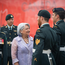 La gouverneure générale s'entretient avec des membres de la garde d'honneur portant l’uniforme des Forces armées canadiennes.
