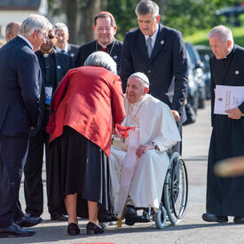 Le Pape François est transporté en fauteuil roulant sur le terrain de la GGCitadelle. La gouverneure générale Simon le salue.