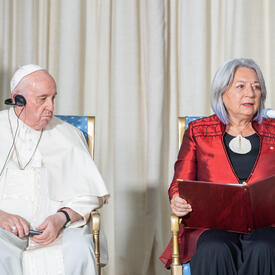 La gouverneure générale Simon est assise à côté de Sa Sainteté le pape François dans une salle du GGCitadelle. Elle a un livre ouvert sur ses genoux.