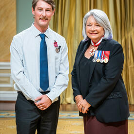 Bravery recipient Trevor Vanderhyden is standing next to the Governor General.
