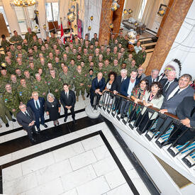La délégation représentant le Canada aux activités commémoratives à Londres en l'honneur de Sa Majesté la Reine. Le grand groupe de personnes regardent vers le haut, en direction du photographe.