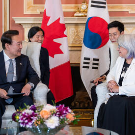Son Excellence Yoon Suk Yeol, président de la République de Corée, est assis en face de la gouverneure générale. Deux personnes sont assises derrière eux.