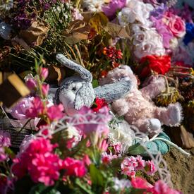 Un monticule de fleurs et d’animaux en peluche.
