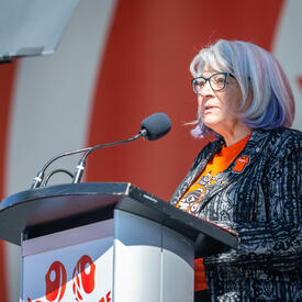 Governor General Mary Simon is standing on a stage behind a podium. She is speaking into a microphone.