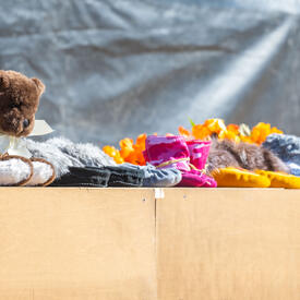 A row of children’s shoes on the edge of a stage. 