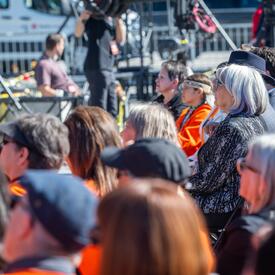 The Governor General is in the crowd, looking up towards the stage.