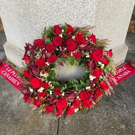 Il y a une couronne sur un mémorial au cimetière de Fossvogur. Le texte sur un ruban rouge à côté de la couronne indique : « Le peuple du Canada » (en anglais).