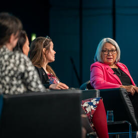 La gouverneure générale Mary Simon et trois autres personnes sont assises dans des fauteuils noirs. La gouverneure générale parle et les trois autres panélistes la regardent.