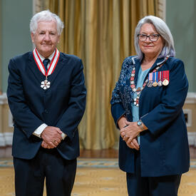 Donald Joseph Savoie is standing next to the Governor General.