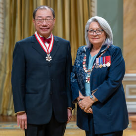 Shoo Kim Lee est debout à côté de la gouverneure générale.