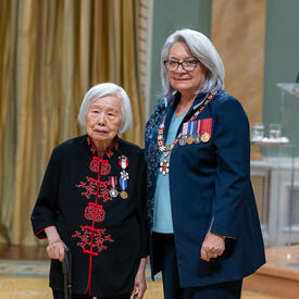 Lily Siewsan Chow is standing next to the Governor General.