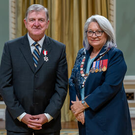 Roger D. Grimes is standing next to the Governor General.