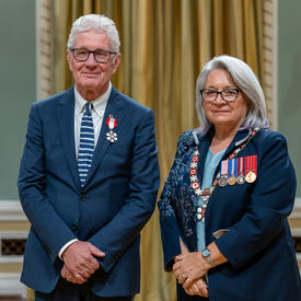 Donald R. M. Schmit is standing next to the Governor General.