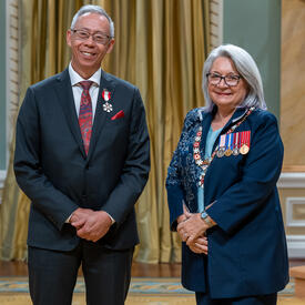 Howard Timothy Lee Soon is standing next to the Governor General.