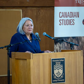 La gouverneure générale est debout sur un podium. Une diapositive avec les mots « Canadian Studies » se trouve à sa gauche.