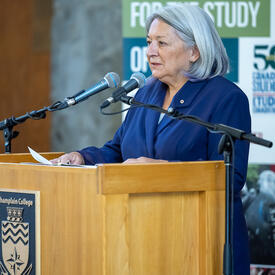 Side angle of the Governor General speaking at a podium.