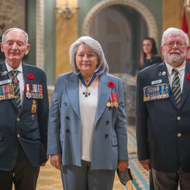 La gouverneure générale pose avec deux hommes de la Légion royale canadienne.