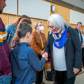 La gouverneure générale serre la main des bénévoles et des membres de la communauté.