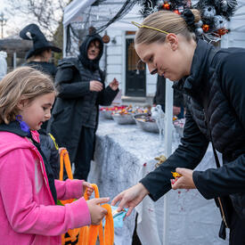 A young child is receiving Halloween treats.