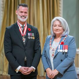 Mark Roger Tewksbury is standing next to the Governor General.