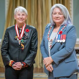 Sandra Louise Kirby is standing next to the Governor General.