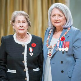 Berna Valencia Garron is standing next to the Governor General.