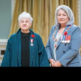 Elizabeth Langley is standing next to the Governor General.