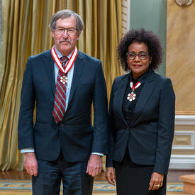 John J. Clague is standing next to The Right Honourable Michaëlle Jean.