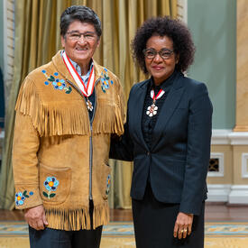 Former National Chief Ovide William Mercredi is standing next to The Right Honourable Michaëlle Jean.