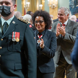  The Right Honourable Michaëlle Jean is clapping as the walks with the procession out of the ballroom.