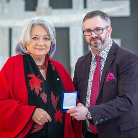 Kelly Hiebert is standing next to the Governor General.