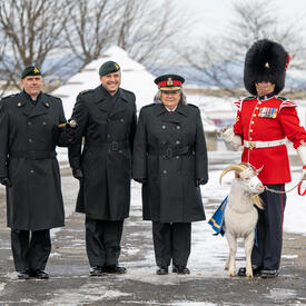La gouverneure générale se tient aux côtés de membres de l'armée, d'une garde de cérémonie et d'une chèvre.