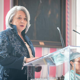 Governor General Simon speaks at a podium in the Tent Room at Rideau Hall during an International Women's Day event.