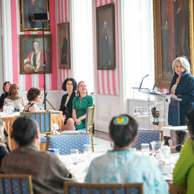A group of women engage in conversation with Governor General Simon, in the Tent Room at Rideau Hall. 