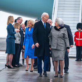 Governor General Simon walks next to U.S President Joe Biden. There is a group of people behind them.