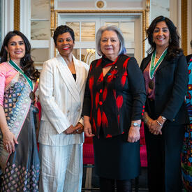 Governor General Simon poses for the photo with four other women / four people.