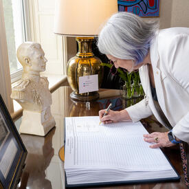Governor General Marie Simon signs a guest book