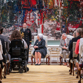Governor General Marie Simon sits in a chair during the ceremony
