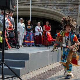 Governor General Marie Simon watches a cultural performance. An indigenous child dances.