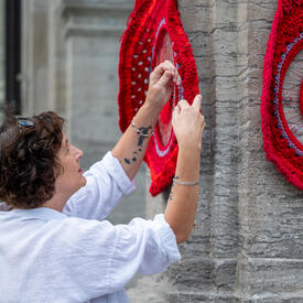 Métis artist Tracey-Mae Chambers hangs her artwork on the porte-cochère of Rideau Hall