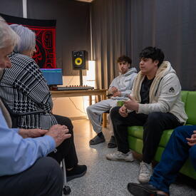 Governor General Mary Simon speaking with young men from the NeXup youth initiative in their music studio.