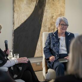 La gouverneure générale Mary Simon assise avec un petit groupe de personnes en pleine discussion. 